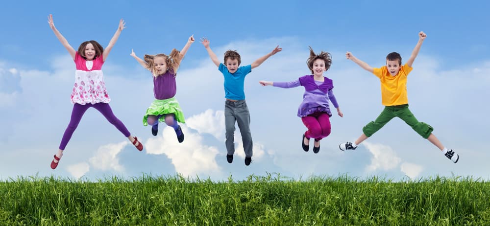Happy children jumping on the spring field